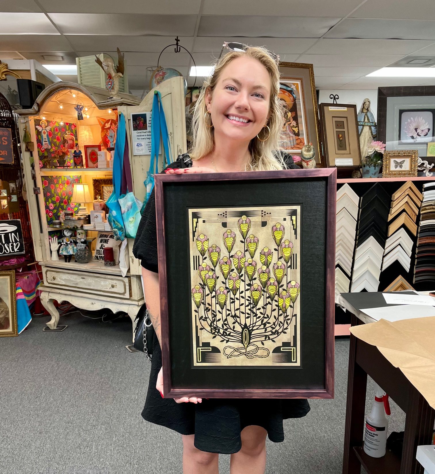 A framed botanical print, held up inside the Art Expressions studio