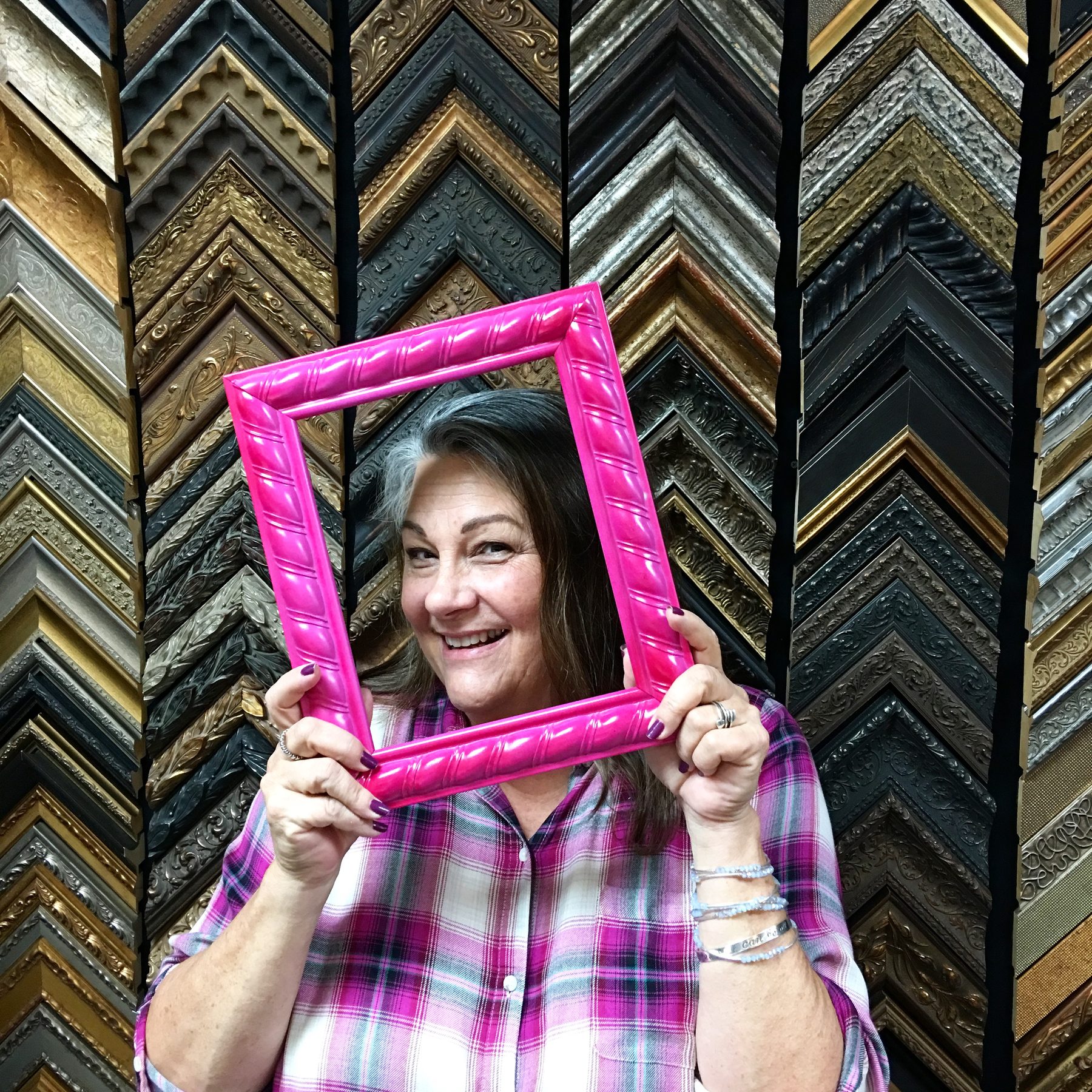 Inside Art Expressions, in front of the floor-to-ceiling frame sample wall